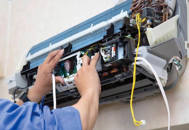 técnico reparando un aire acondicionado estropeado